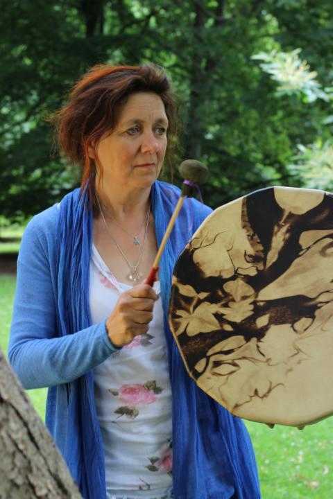 Die Stadtscharmanin Bianka-Maria Meyer während der schamanischen ausbildung mit einer trommel in der hand